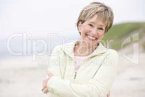 Woman at the beach with arms crossed smiling