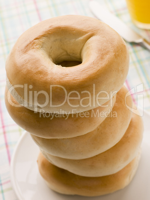 Stack of Plain Bagels with a Glass of Orange Juice