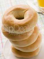 Stack of Plain Bagels with a Glass of Orange Juice