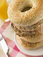 Stack of Seeded Bagels with a Glass of Orange Juice