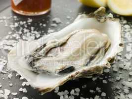 Opened Rock Oyster with Hot Chilli Sauce Lemon and Sea Salt