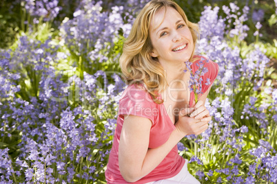 Woman outdoors holding flowers smiling