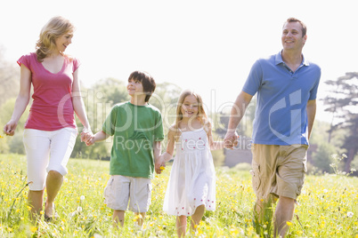 Family walking outdoors holding flower smiling