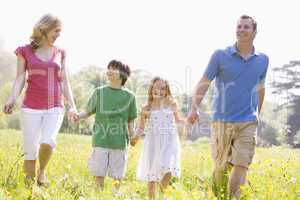 Family walking outdoors holding flower smiling