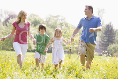 Family walking outdoors holding hands smiling