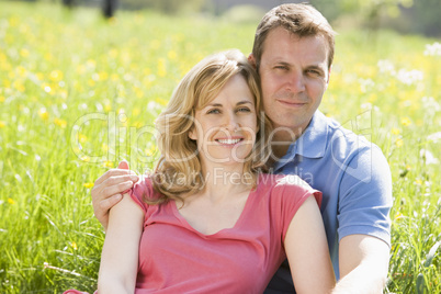 Couple sitting outdoors smiling