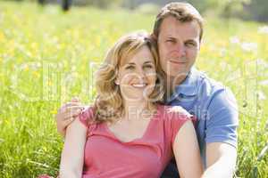 Couple sitting outdoors smiling