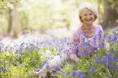 Woman sitting outdoors with flowers smiling