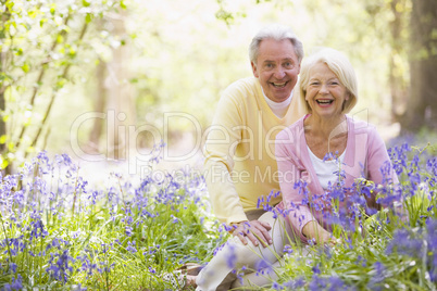 Couple sitting outdoors with flowers smiling