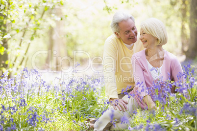 Couple sitting outdoors with flowers smiling