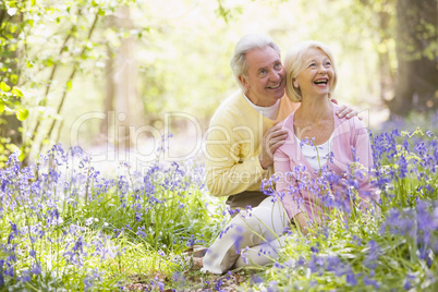 Couple sitting outdoors with flowers smiling