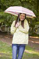 Woman outdoors in rain with umbrella smiling