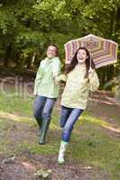 Couple outdoors running with umbrella smiling