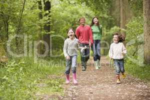 Family walking on path holding hands smiling