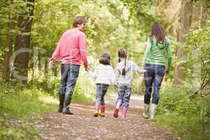 Family walking on path holding hands