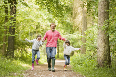 Father and daughters walking on path holding hands smiling