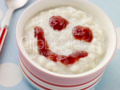 Bowl of Creamed Rice Pudding with a Strawberry Jam Face