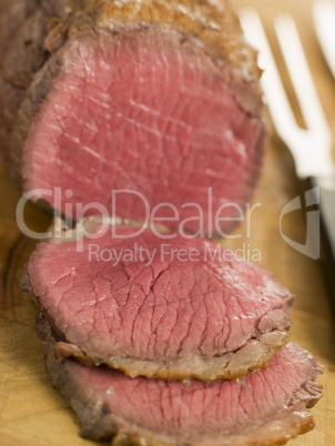 Roast Topside of British Beef carved on a Chopping Board