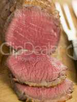 Roast Topside of British Beef carved on a Chopping Board