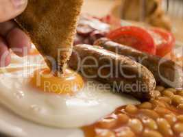 Dipping Toast into a Fried Egg on a Full English Breakfast