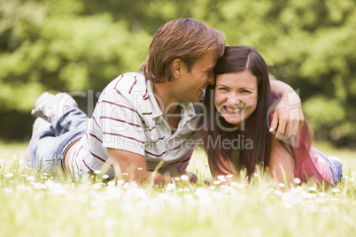 Couple lying outdoors smiling