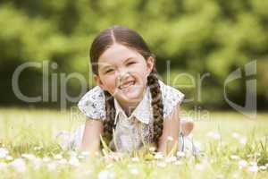 Young girl lying outdoors smiling