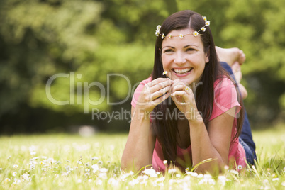 Woman lying outdoors with flowers smiling