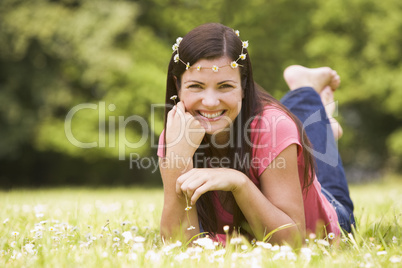 Woman lying outdoors with flowers smiling