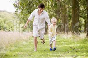 Father and son running on path smiling