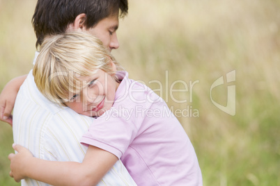 Father holding son outdoors smiling