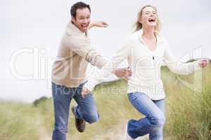 Couple running at beach smiling