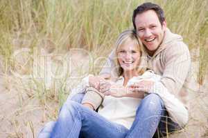 Couple sitting on beach smiling