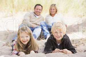 Family relaxing on beach smiling