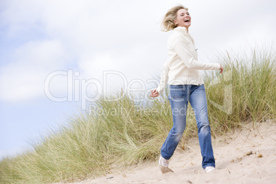 Woman walking on beach smiling