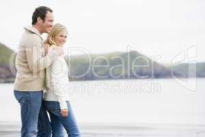 Couple standing on beach smiling