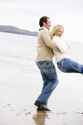 Couple playing on beach smiling