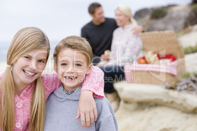 Family at beach with picnic smiling