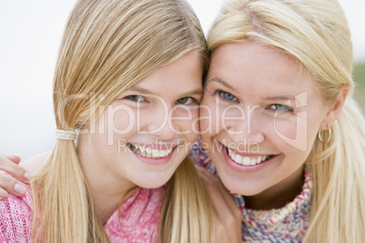 Mother and daughter at beach smiling