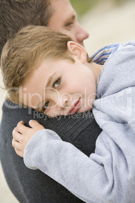 Father holding son at beach