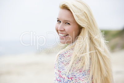 Woman standing at beach smiling