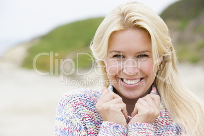 Woman standing at beach smiling