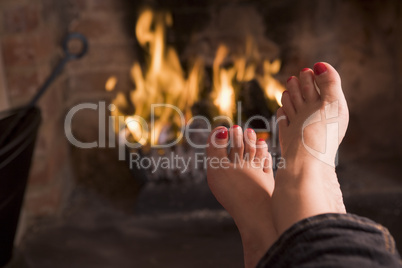 Feet warming at a fireplace