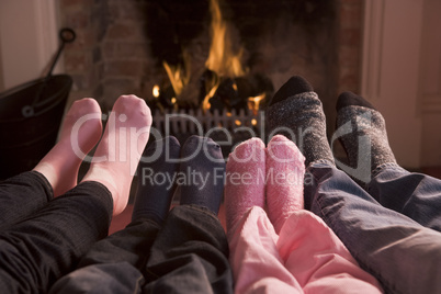 Family of Feet warming at a fireplace