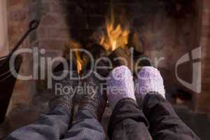 Couple's feet warming at a fireplace