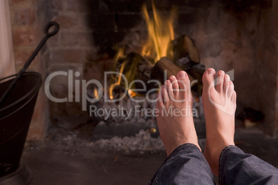 Feet warming at a fireplace