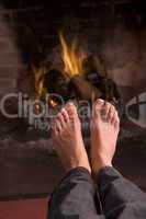 Feet warming at a fireplace