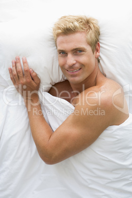 Man lying in bed smiling