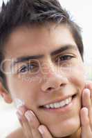 Man applying shaving cream smiling
