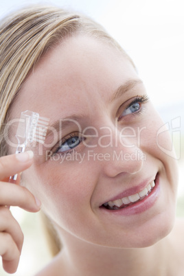 Woman with eyebrow brush smiling