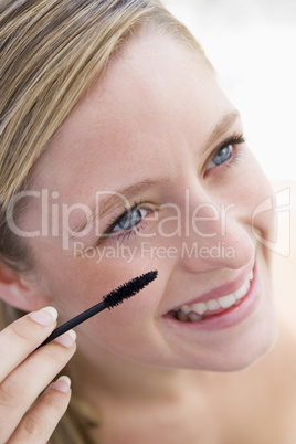 Woman with mascara wand smiling